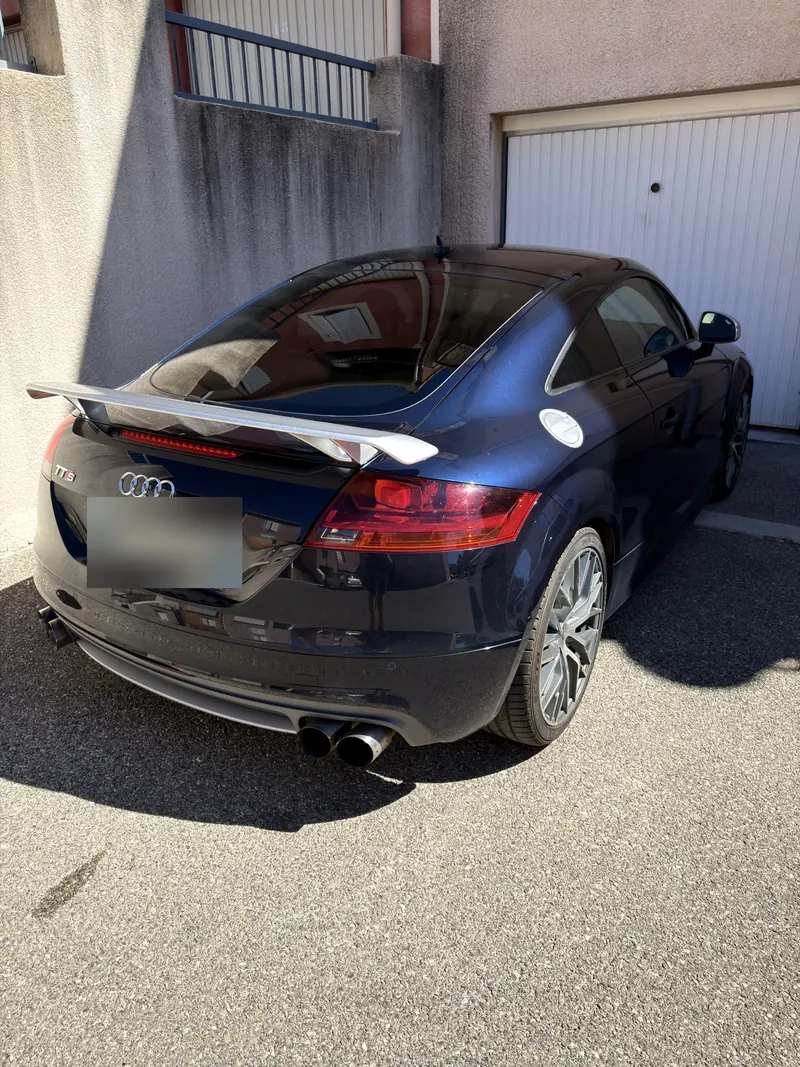 Vue arrière de l'Audi TTS Coupé avec son aileron et sa double sortie d'échappement