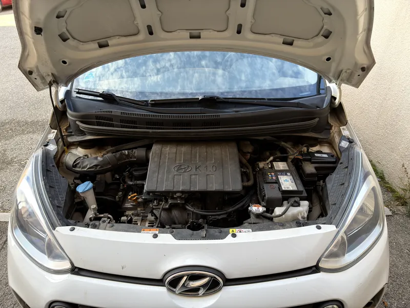 Compartiment moteur de la Hyundai i10 1.0 après la pose du kit E85 : boîtier eFlexBlue fixé à côté de la batterie
