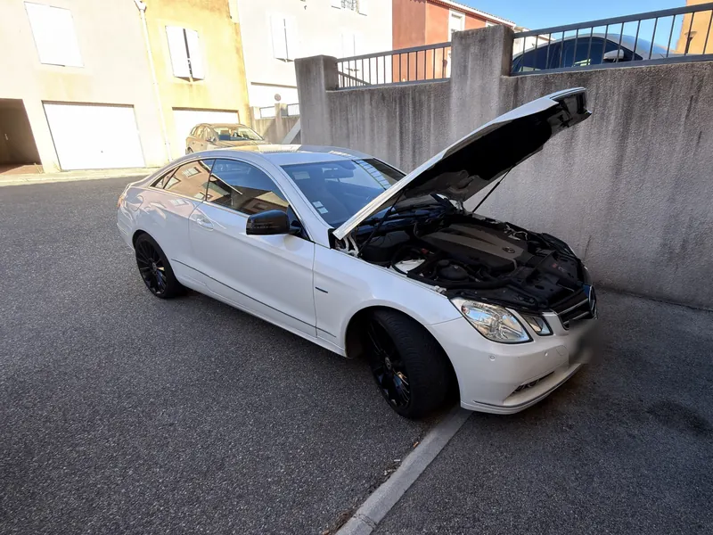 Mercedes Classe E 350 CDI Coupé blanc, capot ouvert pendant sa reprogrammation Stage 1 chez SUD-REPROG