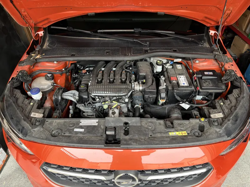 Compartiment moteur de l'Opel Corsa 1.2 : boîtier eFlexBlue posé près de la batterie et plaque d'homologation du kit E85