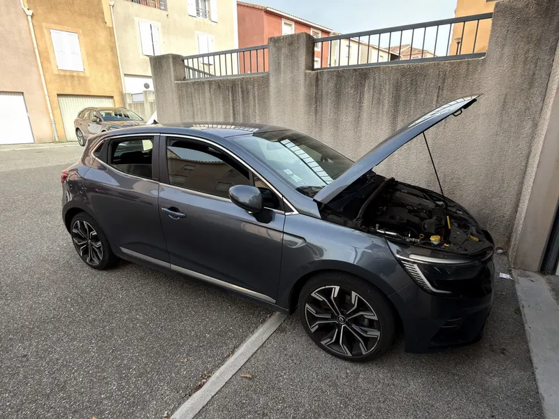 Renault Clio E-Tech hybride 140 grise, capot ouvert pendant la pose de son kit E85 homologué eFlexBlue